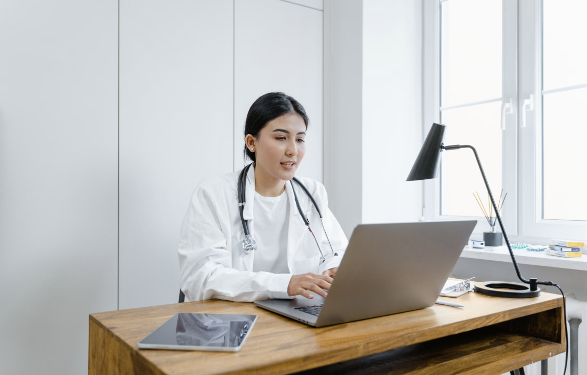 Doctor working at a laptop in a modern clinic office